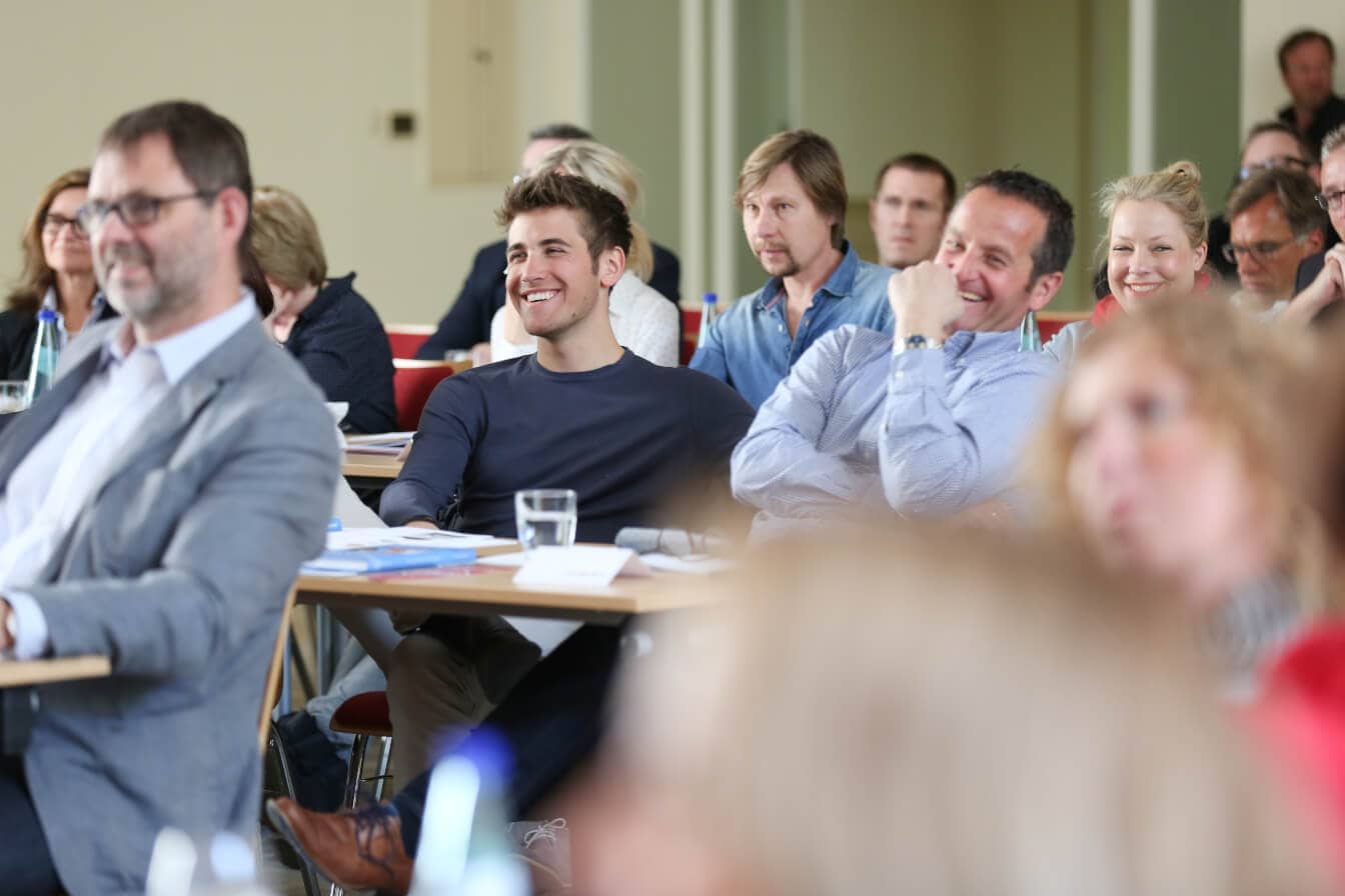 Teilnehmer hören einem Keynote Speaker Vertrieb zu.