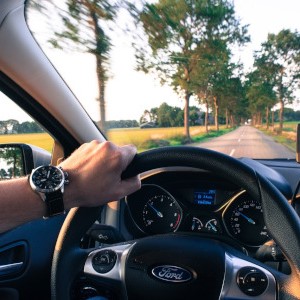 Ein Außendienstmitarbeiter fährt mit seinem Auto.